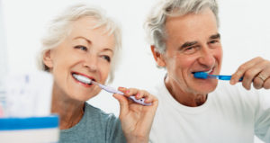 Cacausian woman man brushing teeth smiling